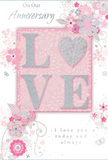 In this image, an anniversary card is presented in close detail, its design a soft celebration of lasting romance, like a couple's familiar walk from Manor House station toward the leafy edges of Finsbury Park. The colour palette is unashamedly gentle: pastel pinks melt into silvery greys and whites, creating the feeling of a cherished keepsake rather than a loud statement. At the centre of the card, the word LOVE appears in raised, softly glittering letters, giving the impression of fine sugar crystals dusted along each stroke. The O in LOVE is transformed into a shimmering silver heart, slightly textured and bright, becoming the emotional anchor of the design. Around this central motif, delicate blooms in blush and mauve unfurl as if painted with a fine, watercolour wash. Their outlines and veins are picked out in smooth, flowing lines that echo the curved stems and trails a florist might create when shaping a romantic bouquet for local delivery. Tiny flourishes-loose petals, swirling tendrils, and discreet butterfly silhouettes-flutter through the composition, adding an impression of light movement, like a breeze stirring flowers in a small city garden off Seven Sisters Road. Above and below the floral artwork, the words On Our Anniversary and I love you today and always are written in a gentle, understated script that feels sincere and heartfelt. The entire card carries a sense of occasion that is quiet but deeply meaningful, perfectly suited to sit beside a vase of fresh flowers in a Manor House living room as two people pause to remember the journey they have shared so far.